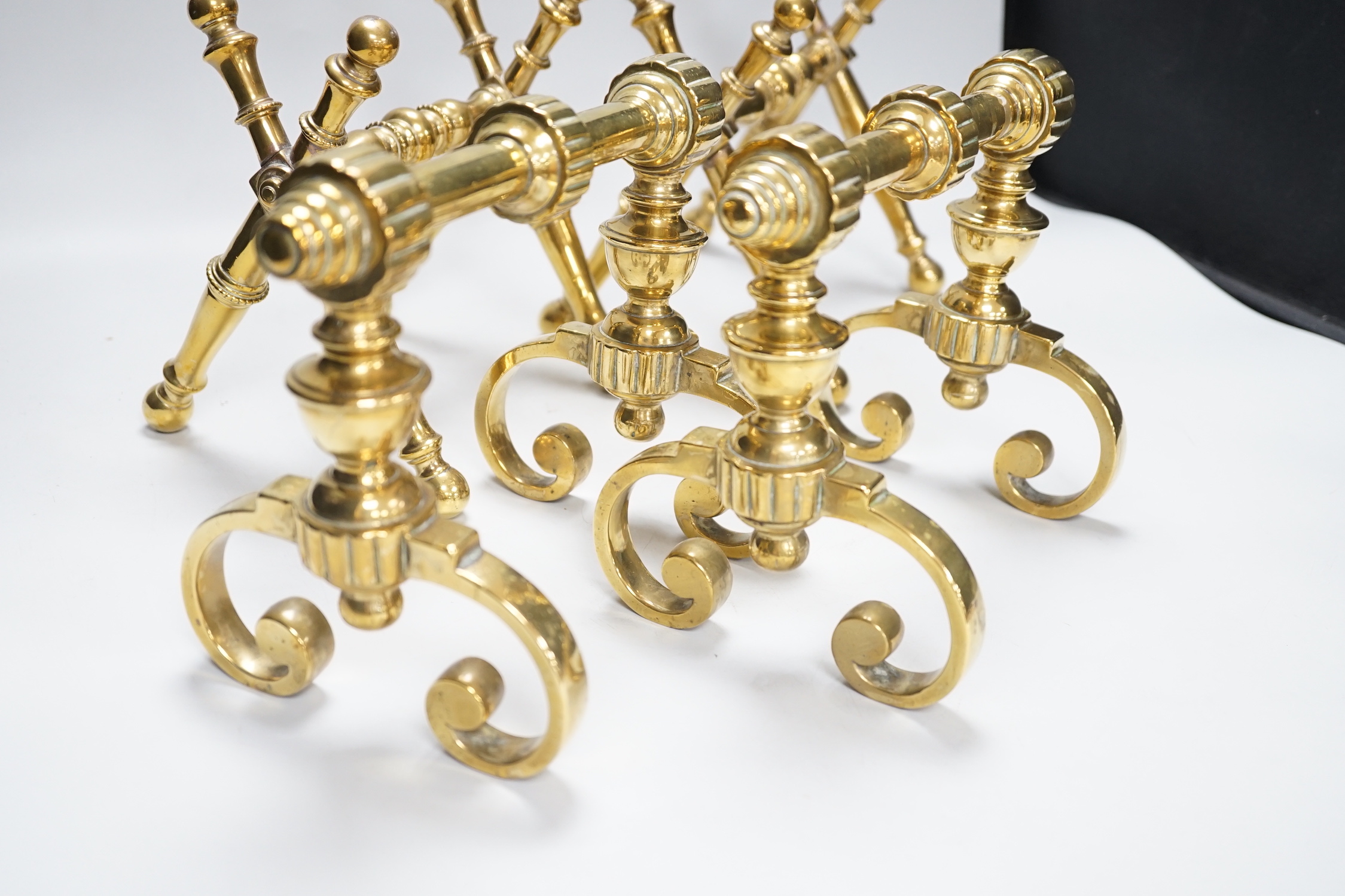 Two sets of brass fire dogs in Christopher Dresser style, the largest 18cm high